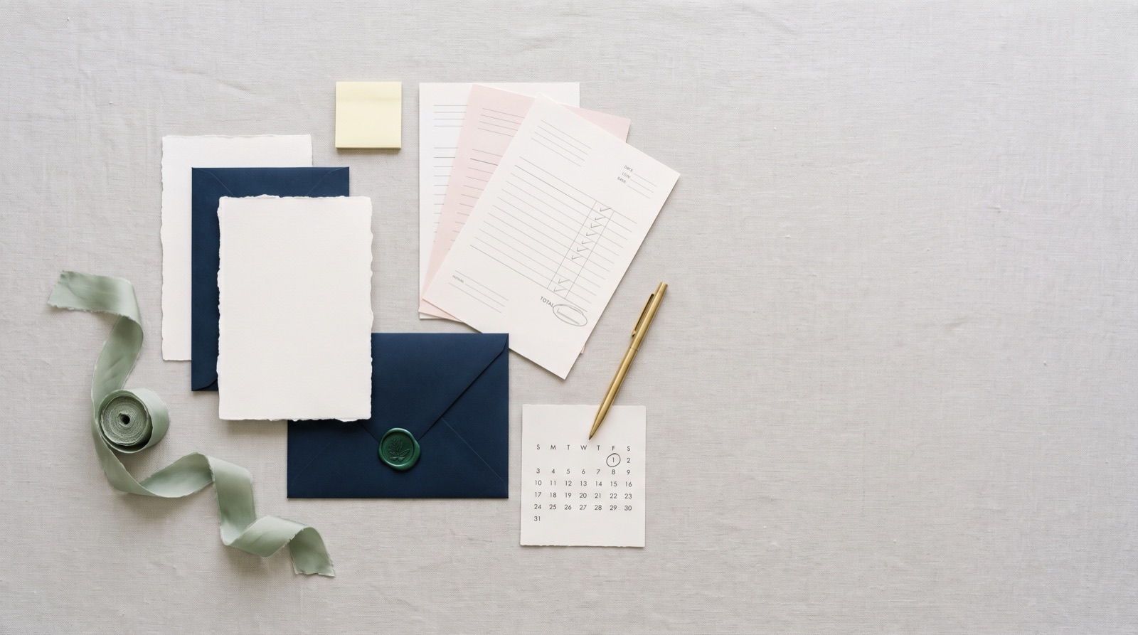 Illustrative wedding stationery and planning notes on linen